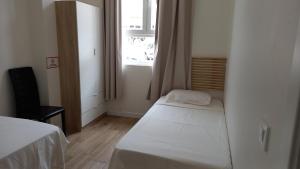 Habitación pequeña con cama y ventana en Cervante Apartment, en Alcalá de Henares
