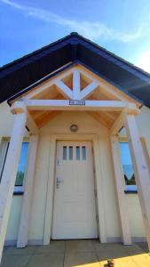 a garage with a white door and a black roof at Domek Na Ustroniu in Sasino