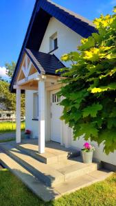 una piccola casa bianca con un garage bianco di Domek Na Ustroniu a Sasino