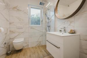 a white bathroom with a toilet and a mirror at 3Level Apartments Kroatien in Umag +25 photos