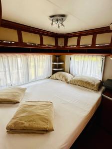 uma grande cama branca num quarto com janelas em PS-Caravaning auf Union Lido - Wohnwagenvermietung em Cavallino-Treporti