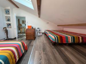 twee bedden in een kamer met houten vloeren bij Le 7 in Capbreton