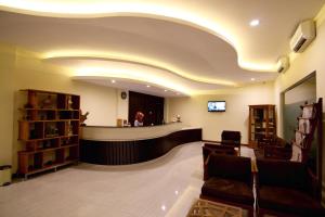 a waiting room with a counter and a woman in a mirror at Syailendra Hotel Syariah in Jepara