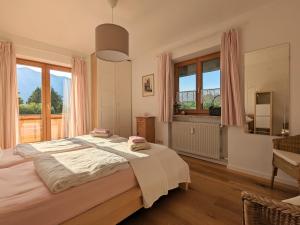 a bedroom with a large bed with pink curtains at Lieblingsort in Unterwössen