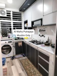 una cocina con armarios blancos y electrodomésticos blancos en AL-WAFRY PUTRAJAYA Presint 16 - Bersebelahan Everly Alamanda Mall, en Putrajaya