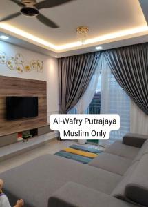 ein Wohnzimmer mit einem Sofa und einem TV in der Unterkunft AL-WAFRY PUTRAJAYA Presint 16 - Bersebelahan Everly Alamanda Mall in Putrajaya