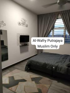 1 dormitorio con 1 cama y TV en la pared en AL-WAFRY PUTRAJAYA Presint 16 - Bersebelahan Everly Alamanda Mall, en Putrajaya