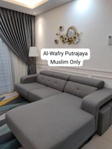 - un salon avec un canapé et un réveil sur le mur dans l'établissement AL-WAFRY PUTRAJAYA Presint 16 - Bersebelahan Everly Alamanda Mall, à Putrajaya