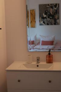 uma casa de banho com um lavatório, um espelho e uma cama em Bedebike em Óbidos