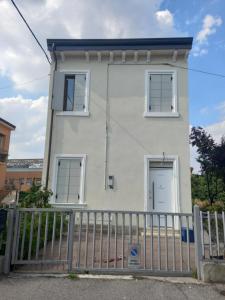 una casa bianca con due finestre e un cancello di Arena in fiera a Verona