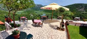 eine Terrasse mit einem Tisch, Stühlen und einem Sonnenschirm in der Unterkunft Rooms Dujeva Drago-Resort in Rijeka Crnojevića