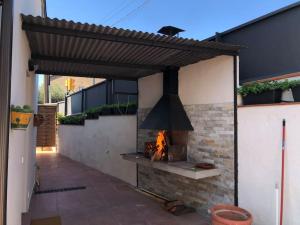 uma cozinha exterior com lareira e fogão em CASA CENTRO DEL PUEBLO CON PISCINA PRIVADA em Sant Vicenç de Montalt