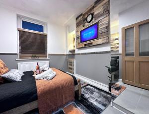 Llwyn-y-pia的住宿－Rustic Rhondda Retreat with Hot Tub & Sauna - Ystrad，一间卧室配有一张床,墙上配有电视