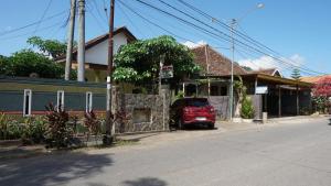 a red car parked in front of a house at OYO 92744 Coconut Island Homestay & Resort in Pasanggaran