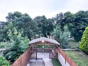 a gazebo with two benches in a garden at Rustic Rhondda Retreat with Hot Tub & Sauna - Ystrad in Llwyn-y-pia