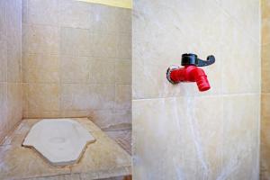 SPOT ON 92730 Lili Kost Syariah في بانيووانجى: حمام به مرحاض وحنفية حمراء