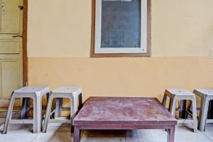 SPOT ON 92730 Lili Kost Syariah في بانيووانجى: طاولة وكراسي في غرفة مع نافذة