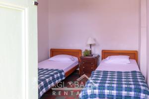 dwa łóżka siedzące obok siebie w pokoju w obiekcie Sandalio Hostal Cali w mieście Cali