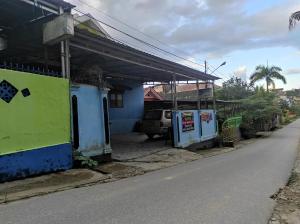 a street with a blue and green building next to a road at OYO 92724 Penginapan Syariah Al Syifa in Kendari