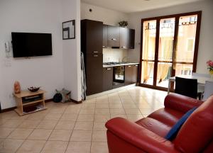 シルミオーネにあるSarno Apartments Via Tintorettoのリビングルーム(赤いソファ付)、キッチン