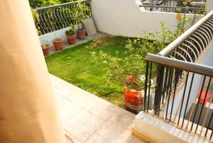 a balcony with a yard of grass and plants at Yellow Homestay - Modern 2BHK AC stay in Jabalpur