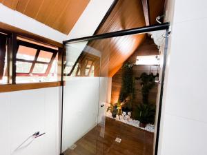 拉夫里尼亞斯的住宿－Pousada Vale das Orquídeas，玻璃门通向种植植物的房间