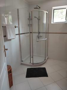 een badkamer met een douche en een glazen deur bij Уютные апартаменты - 400 метров от пляжа in Sutomore