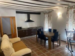 cocina y comedor con mesa y sillas en Agradable casa con chimenea interior y barbacoa., en Graja de Iniesta