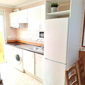 a kitchen with a white refrigerator and a sink at Apt. cerca de la playa y airport in Málaga