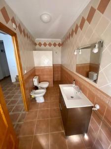 y baño con aseo, lavabo y espejo. en Agradable casa con chimenea interior y barbacoa., en Graja de Iniesta