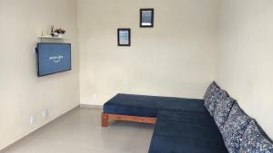a room with a blue couch and a tv at Casa de Temporada Aconchego in Macaé