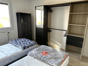 a room with two beds and a closet with shelves at Appartement Cosy Calao - Parking fermé gratuit in Perpignan
