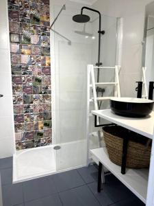 a bathroom with a shower with a sink and a shelf at Appartement Cosy Calao - Parking fermé gratuit in Perpignan