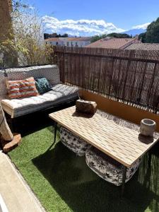 a patio with a bench and a table and a couch at Appartement Cosy Calao - Parking fermé gratuit in Perpignan