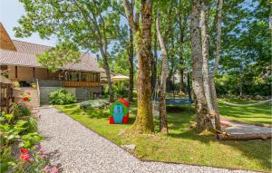 a yard with a playground and a house with trees at Pet Friendly Home In Mazin With Sauna in Mazin