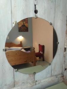 a mirror in a room with a bed and a chair at painter's house in Agios Ioannis