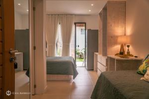 a hotel room with two beds and a bathroom at Casa Amerigo in Morro de São Paulo