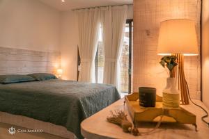 a bedroom with a bed and a table with a lamp at Casa Amerigo in Morro de São Paulo