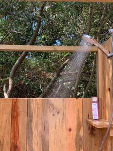 un tuyau d'eau pulvérise sur une clôture en bois dans l'établissement Eco Glamping. Private luxury tent in Alfambras., à Aljezur