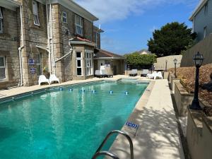 a swimming pool with blue water in front of a building at Queensmead Hotel in Shanklin