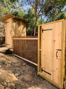 un par de puertas de madera delante de una valla en Eco Glamping. Private luxury tent in Alfambras. en Aljezur