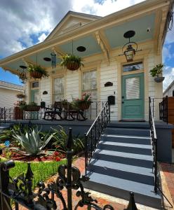 ein Haus mit einer blauen Tür und einer Veranda in der Unterkunft Luxury Historic Shotgun Home in Lower Garden District in New Orleans