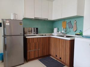 a kitchen with a stainless steel refrigerator and wooden cabinets at Mansion One Seaview 2Bedroom 2Bathroom Georgetown Gleneagles Penang By AmrayHomes in George Town