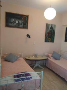 um quarto com duas camas, uma mesa e um candeeiro em painter's house em Ágios Ioánnis