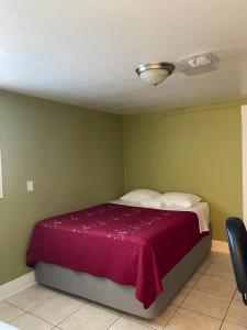a bedroom with a bed with a purple blanket at Spacious Private Los Angeles Bedroom with AC & WIFI & Private Fridge near USC the Coliseum Exposition Park BMO Stadium University of Southern California in Los Angeles