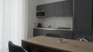 eine Küche mit einem Holztisch mit Stühlen und einer Theke in der Unterkunft Urban Loft Napoli in Neapel + 8 Fotos
