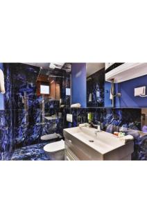 baño con lavabo y pared azul en Green Stone Apartments Hotel en Rafajlovići