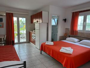 a bedroom with a red bed and a kitchen at 7Syn7 in Oreoi