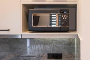 a microwave oven sitting inside of a kitchen cabinet at Aspect Luxury Apartment I in Galangádhos