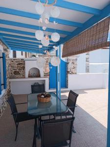 uma sala de jantar com tectos azuis e uma mesa e cadeiras em Queen Stampalia em Astypalaia